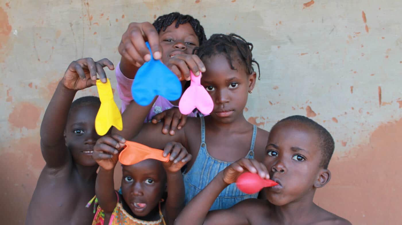 crianças a mostrar balões com forma de coração