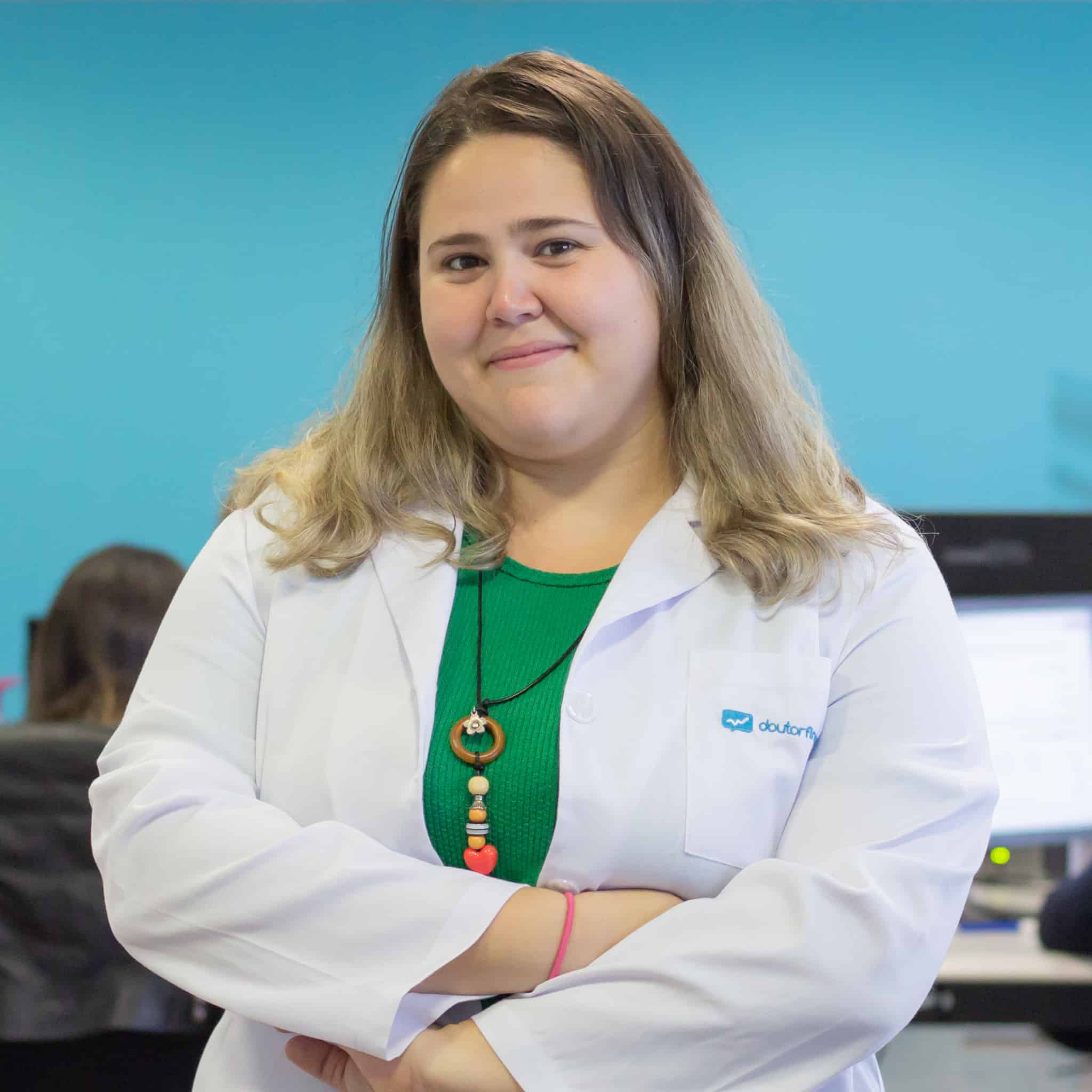 Mulher com bata branca de braços cruzados