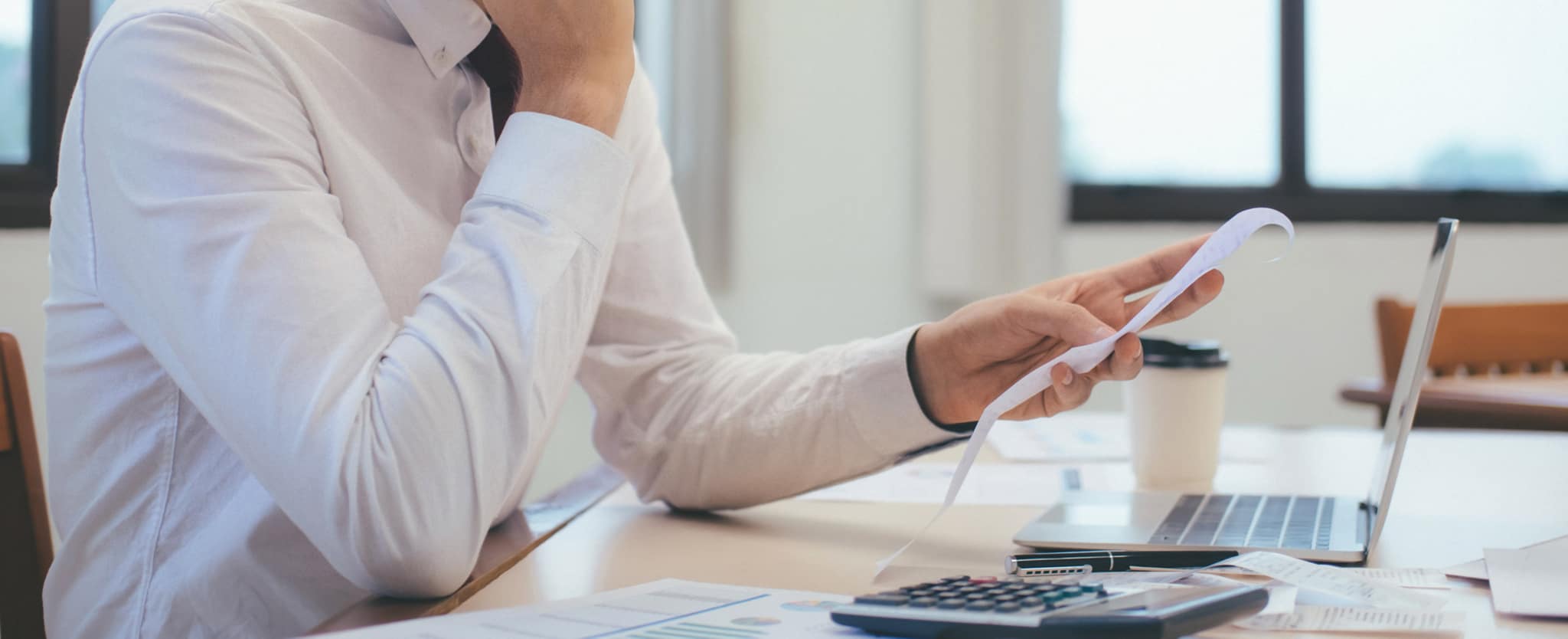 Homem a rever faturas e orçamentos na secretaria