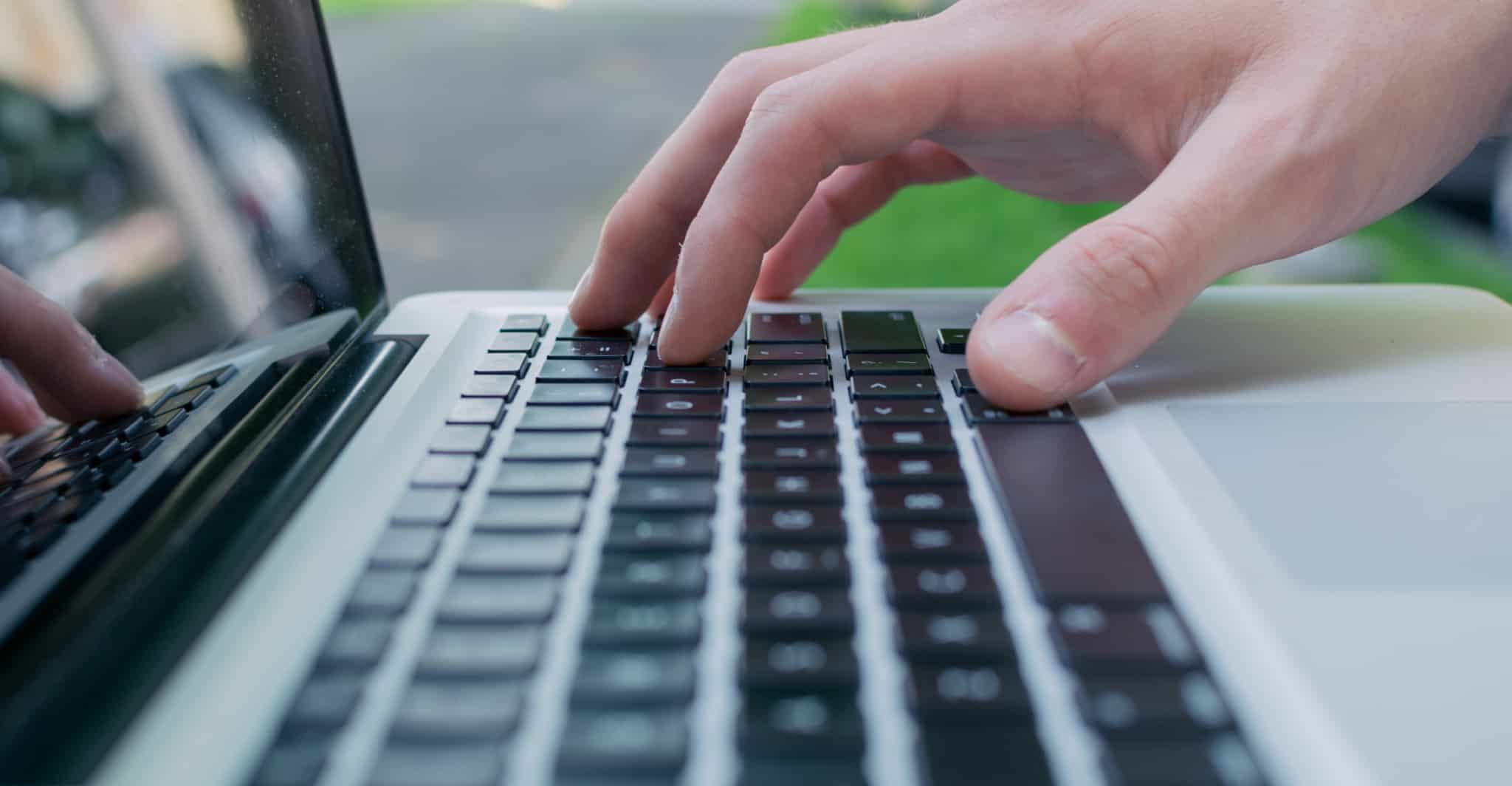 pessoa a escrever no computadorno jardim