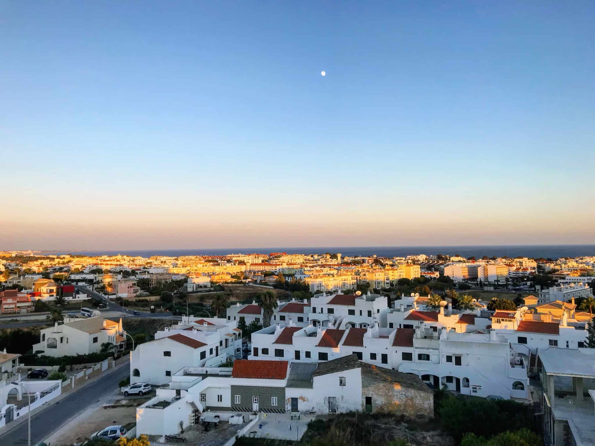 por do sol em faro no meio da cidade com casas brancas