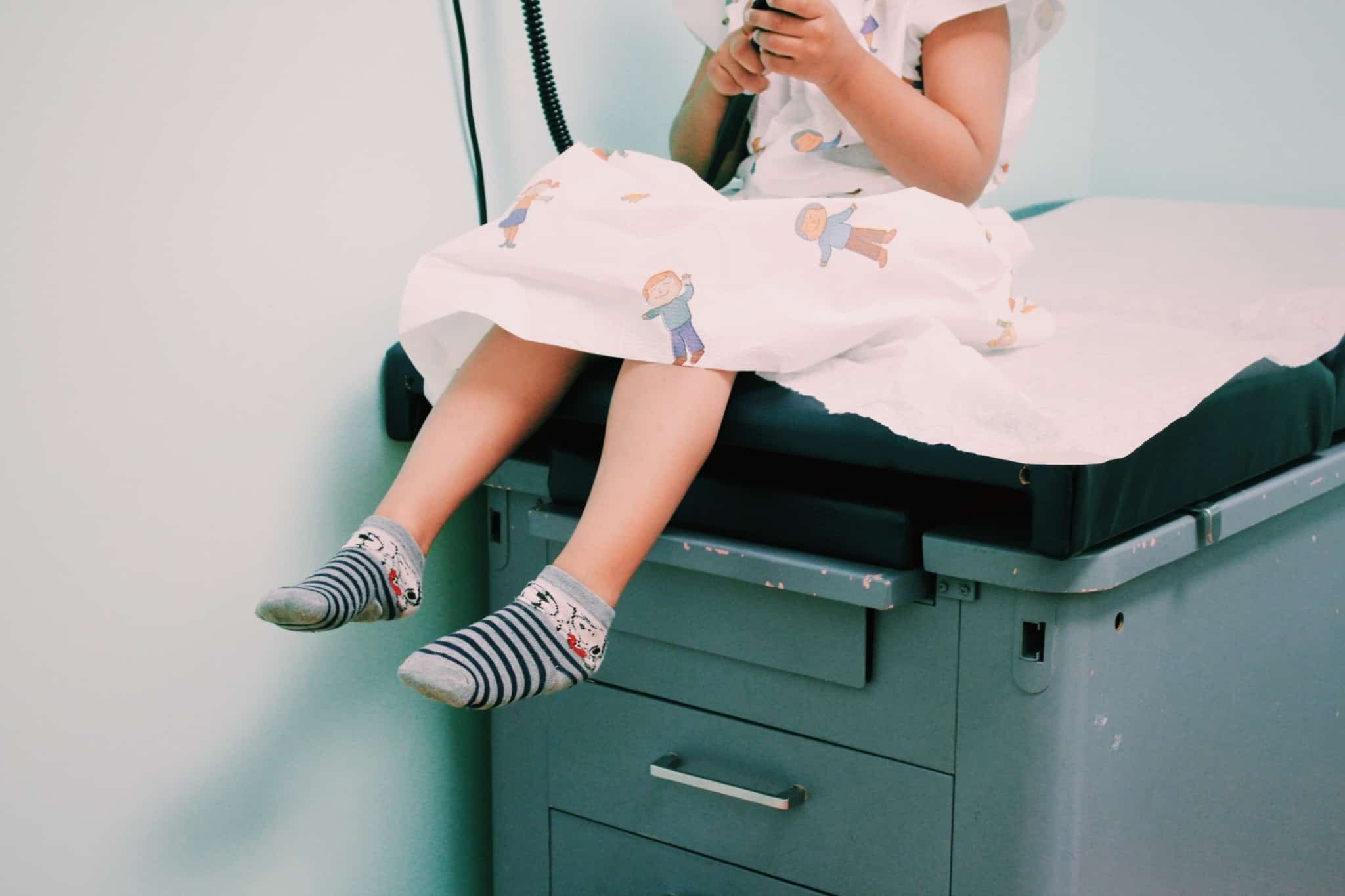 criança sentada à espera do médico