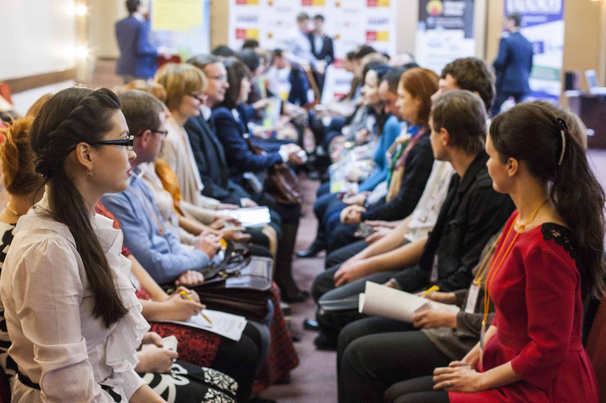 trabalhadores sentados em duas filas frente a frente