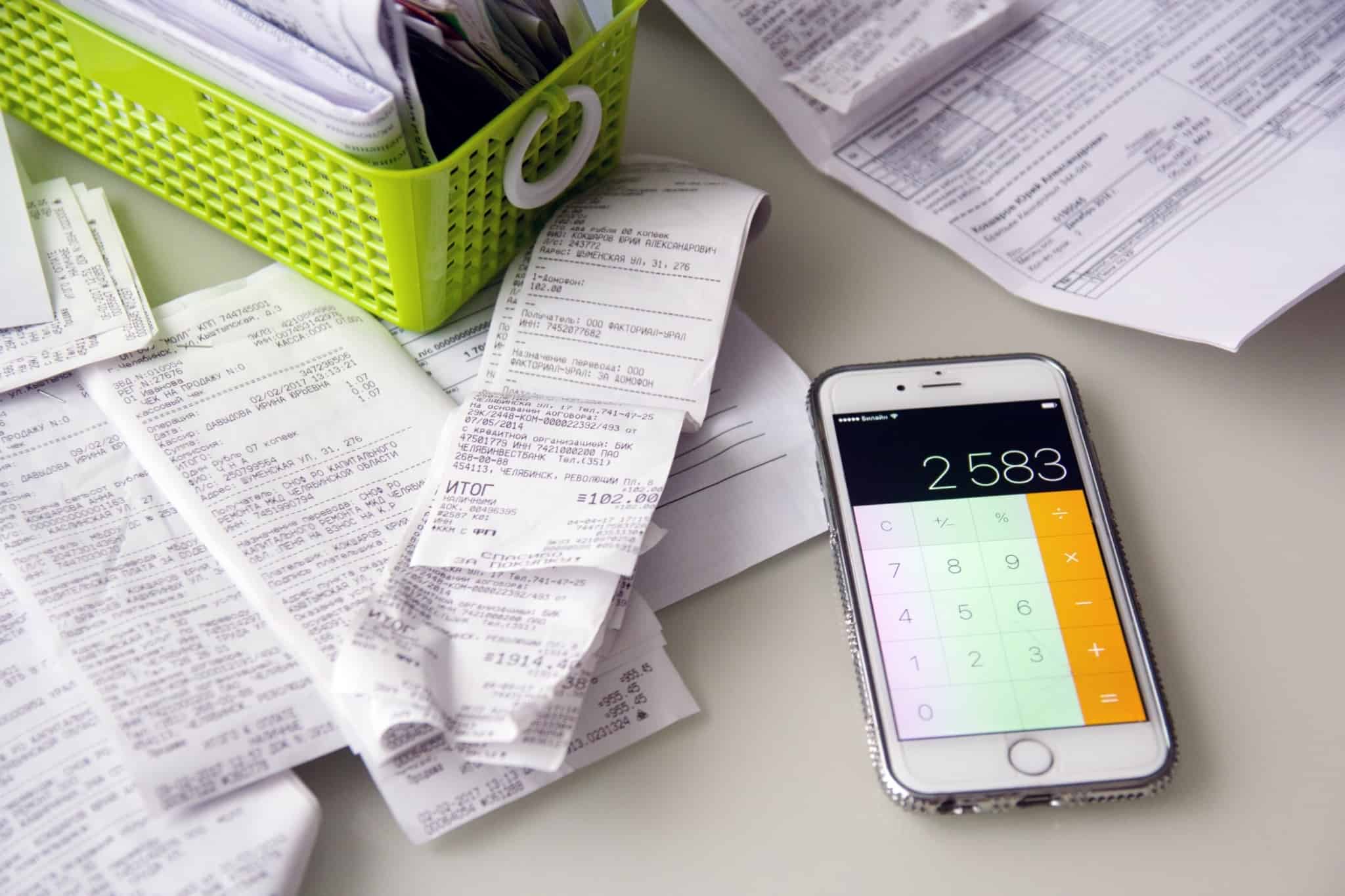 telemovel com a calculadora ligada e os recibos ao lado