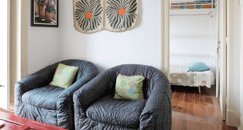 casa com dois sofas e uma cama no fundo