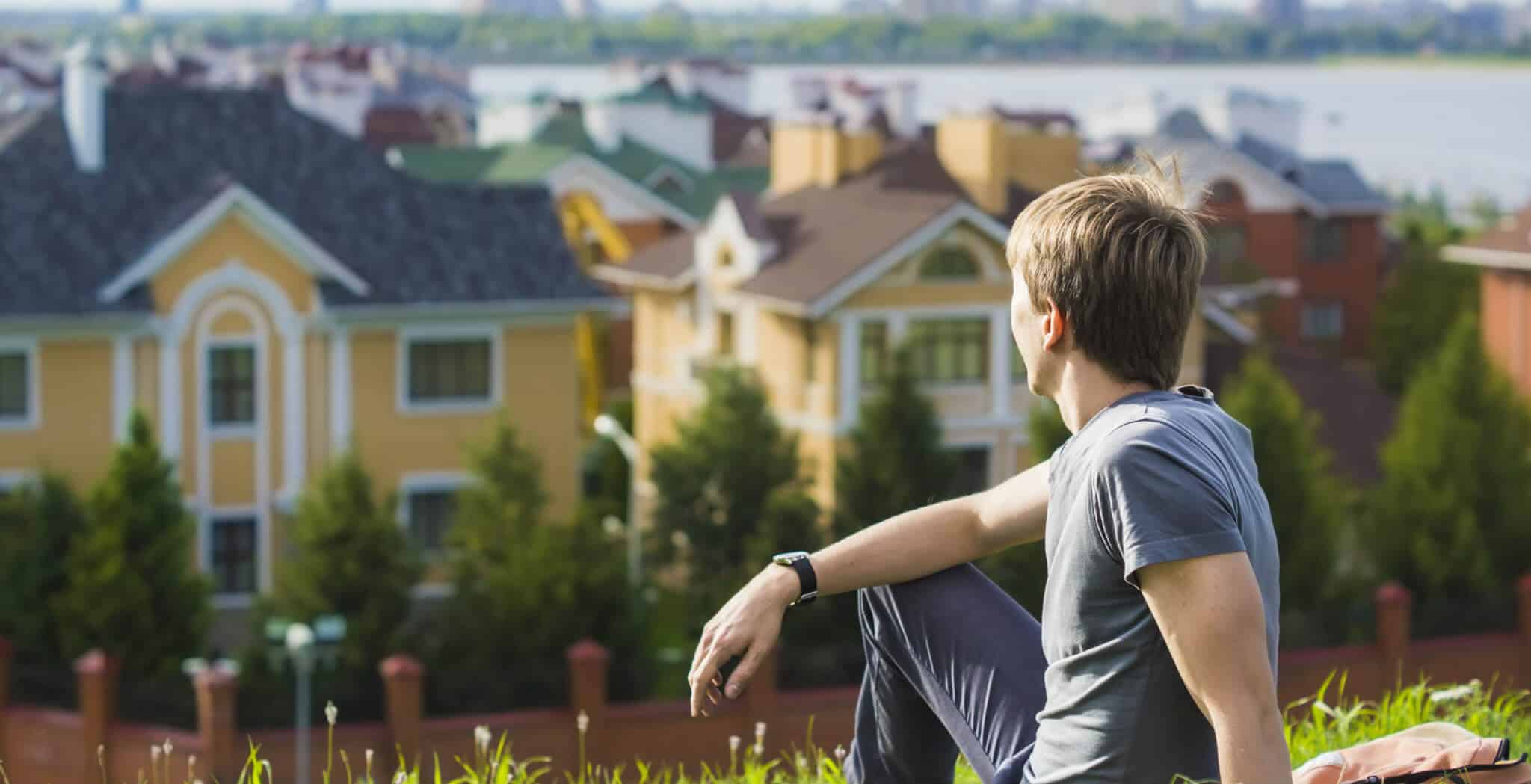 homem sentado a olhar para casas