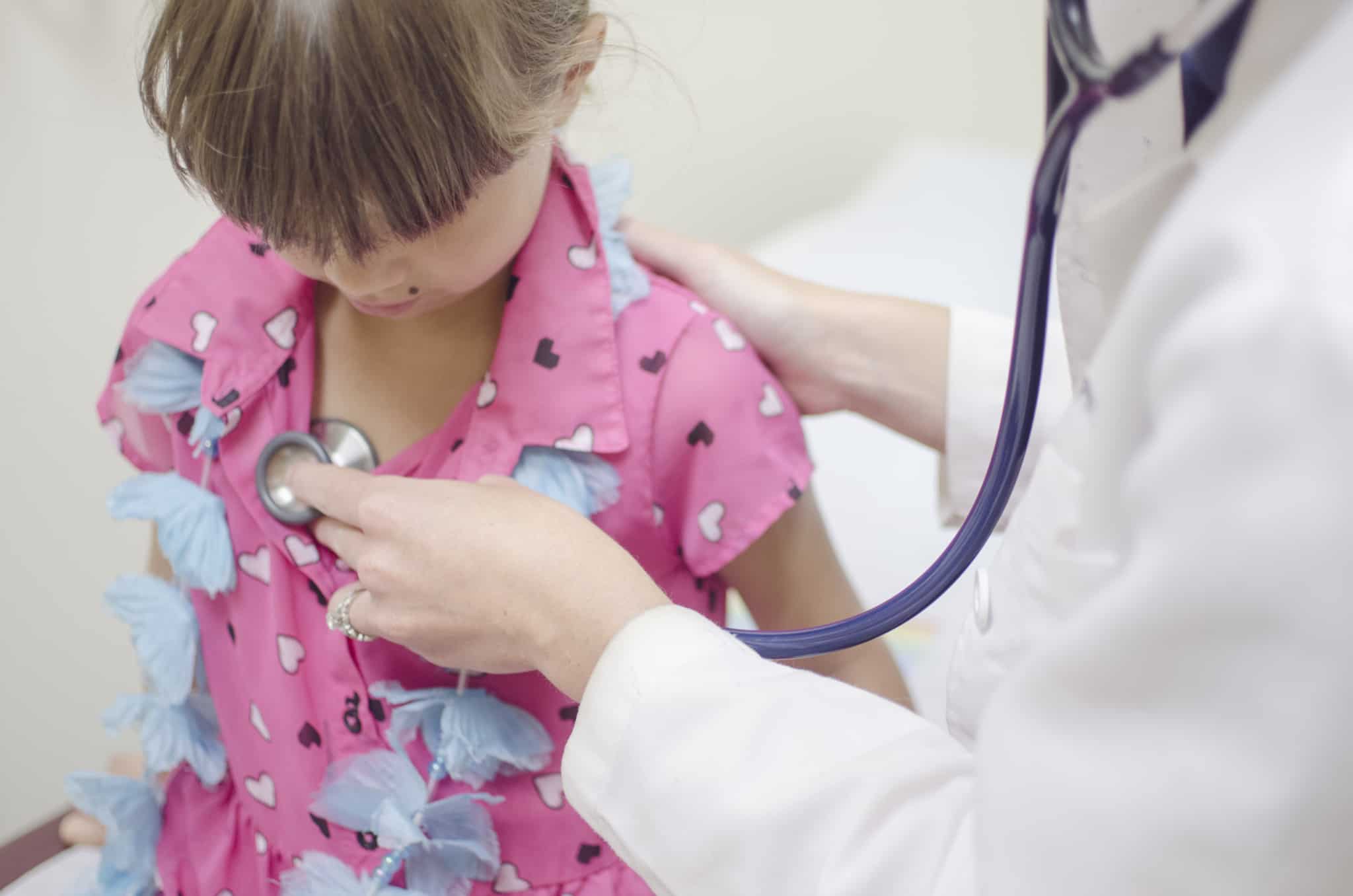 médica a fazer check up a criança com tshirt cor de rosa