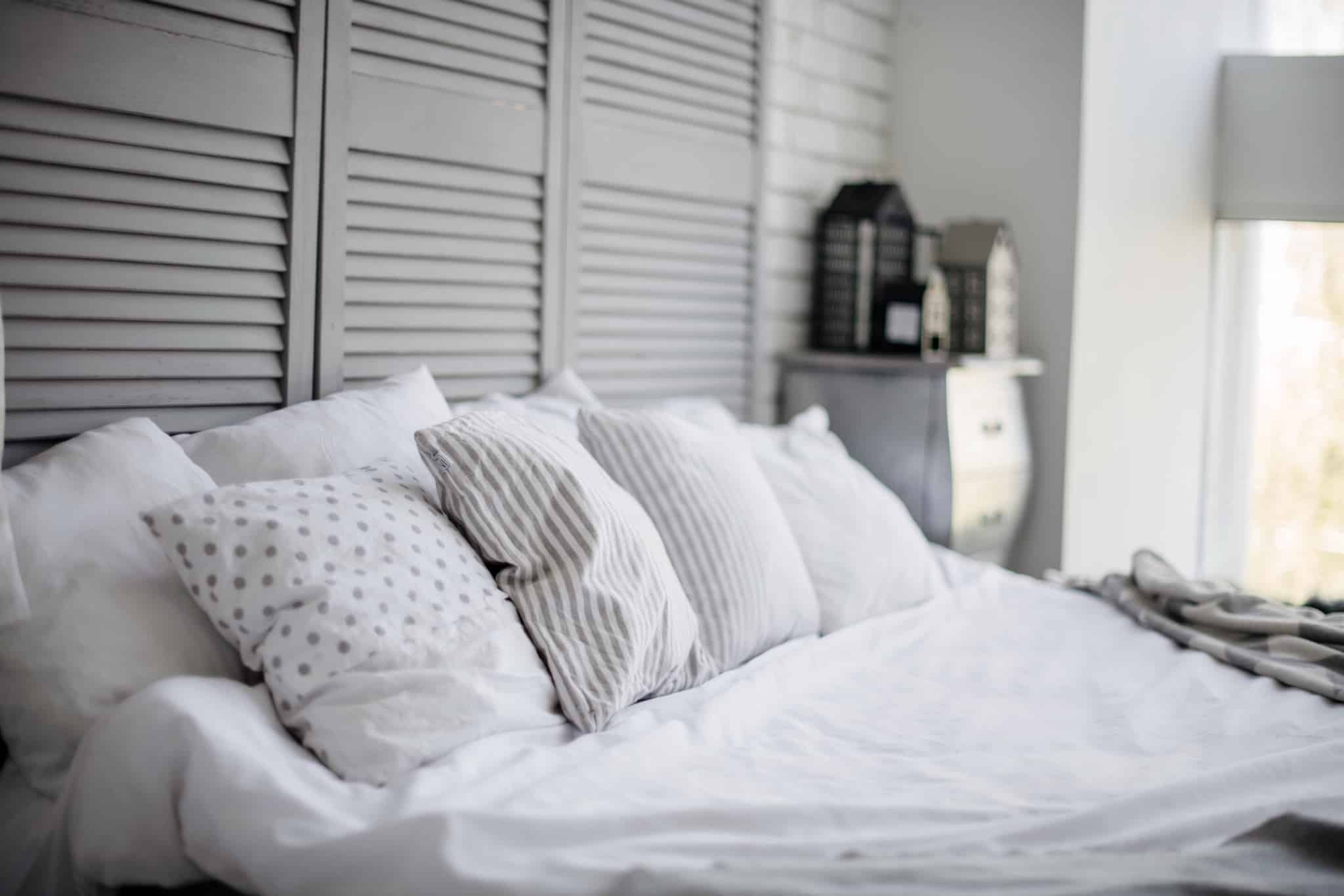 quarto com cama grande e quatro almofadas brancas