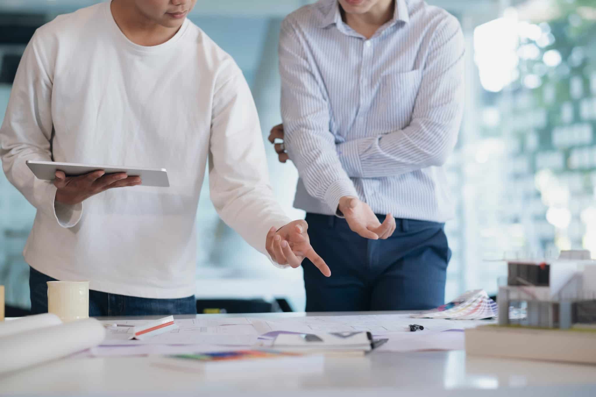 reuniao de duas pessoas a olhar para projeto em cima da mesa