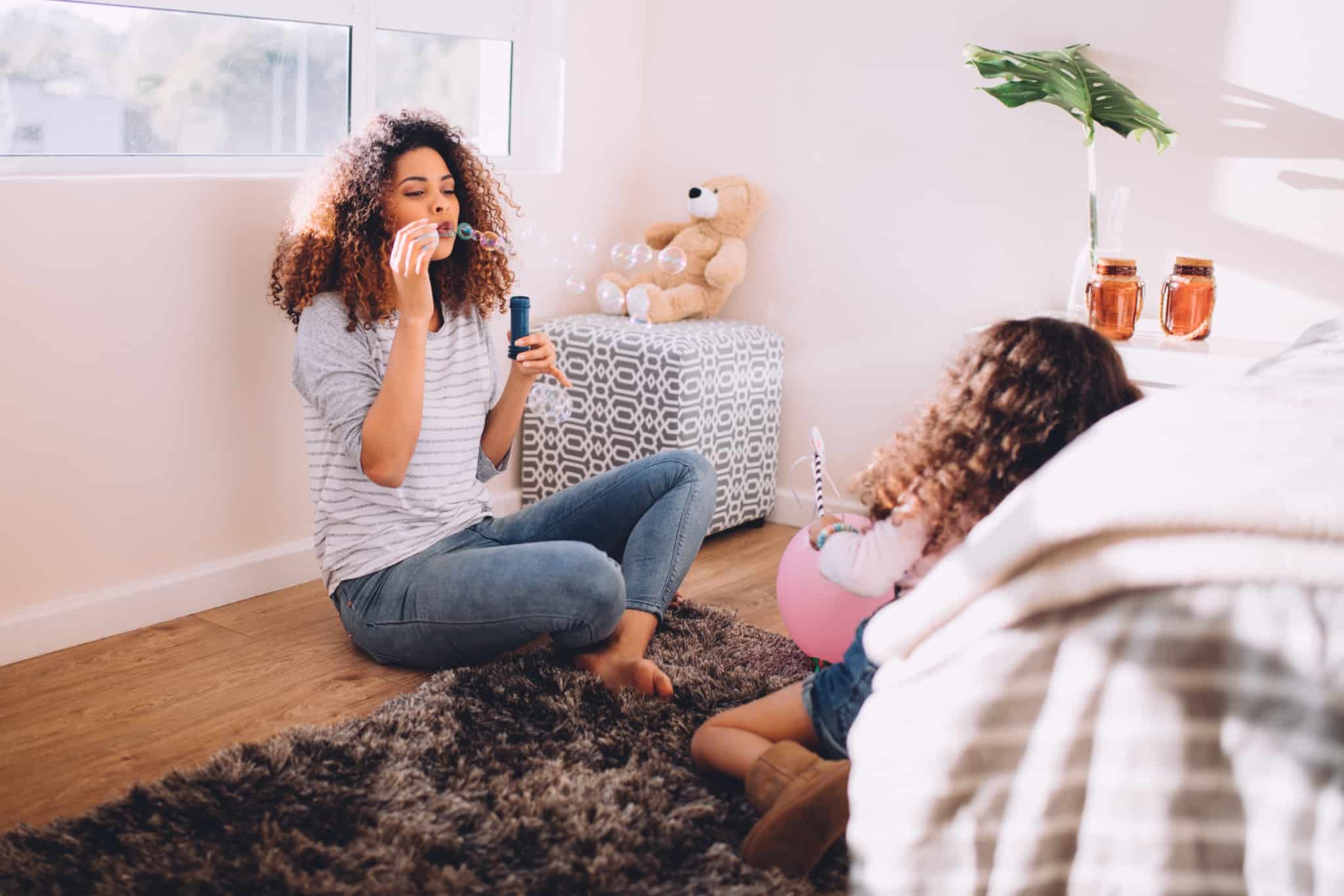 mae e filha a brincar com bolas de sabao
