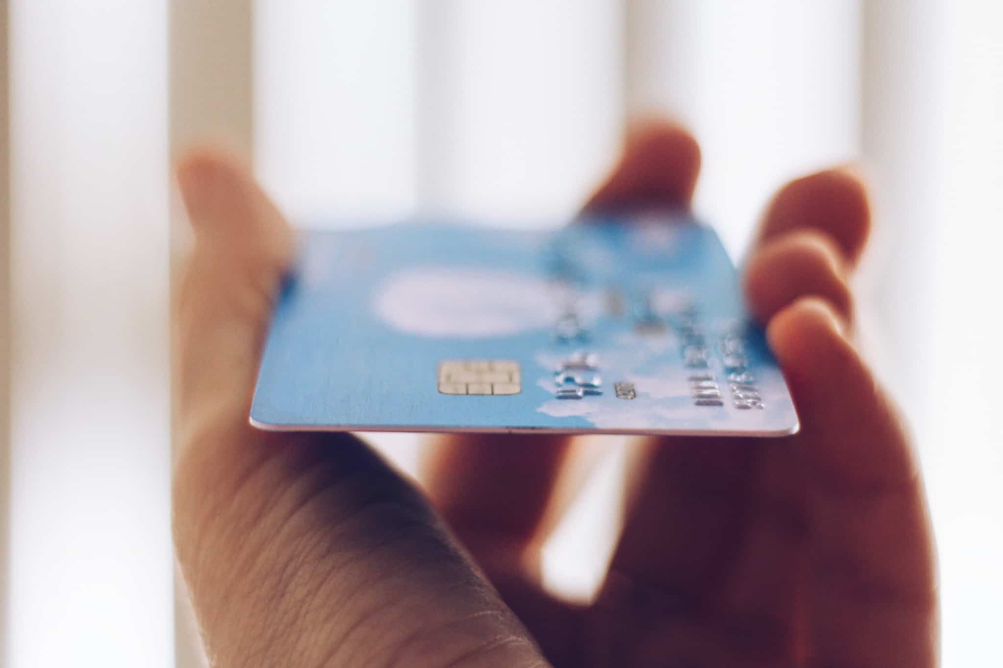 pessoa a segura num cartão de pagamentos