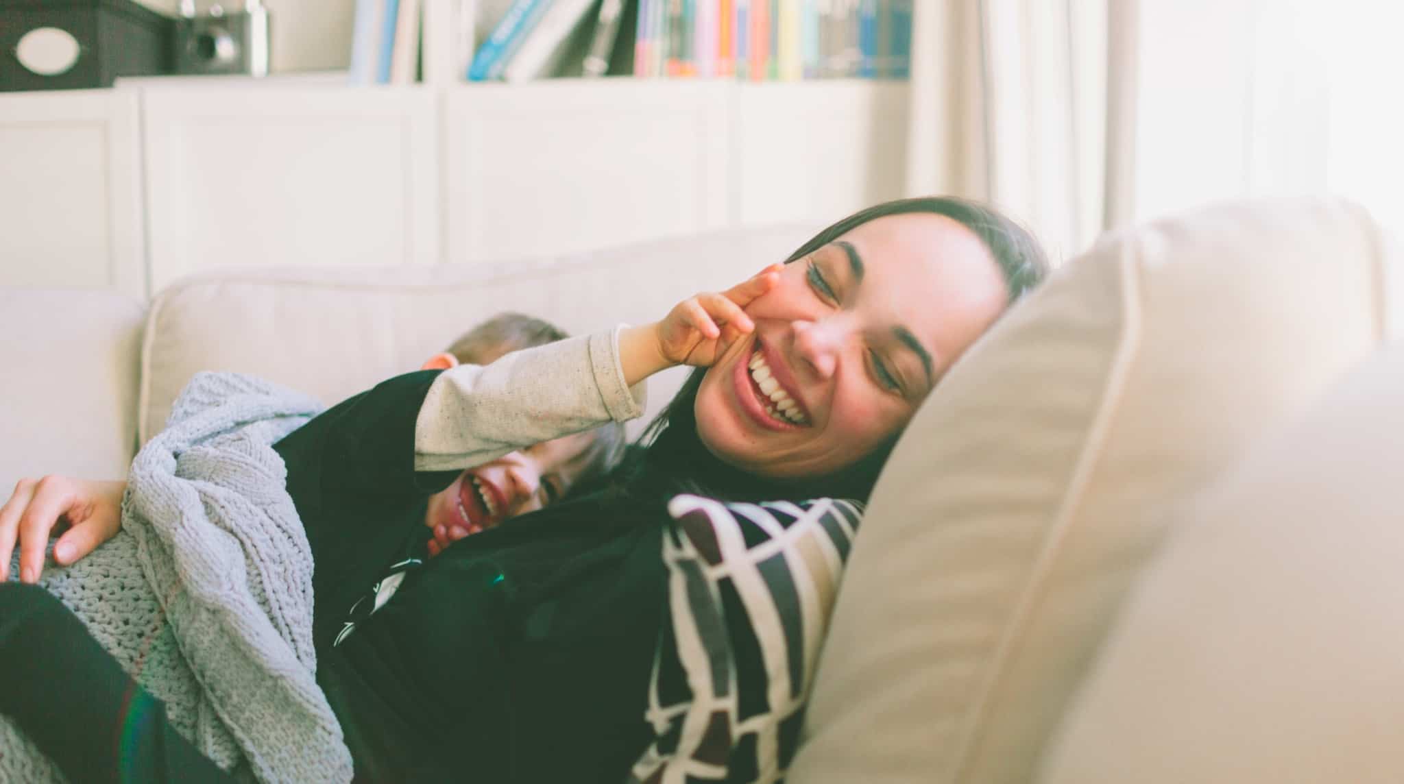 Mãe e filho no sofá a sorrir
